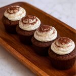 Schoko-Frischkäse-Muffins auf einem dunklen Teller serviert.