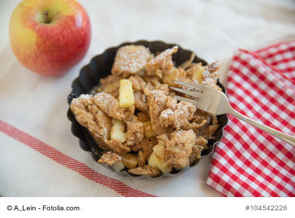 Apfel-Kaiserschmarrn mit Walnüssen in einer Schale traditionell serviert.