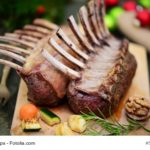 Lammkoteletts mit Kräuterbutter, gelbem Paprikapüree und buntem Gemüse.