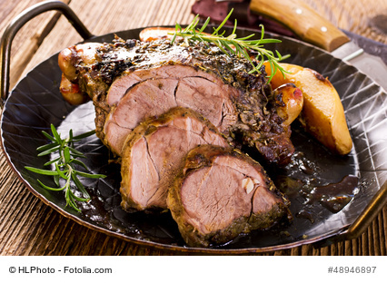 Rustikaler Lammbraten mit feiner Rotwein/Fond-Soße auf einem dunklen Teller angerichtet.
