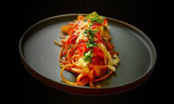 Nun der letze Schritt die Spaghetti all'assassina mit einer langen Gabel etwas gedreht auf einem schwarzen Teller hier drapiert mit etwas frischen dünn geschnitten Chili-Scheiben , etwas Petersilie und nur ein bisschen Parmesan garniert. Die perfekten Spaghetti all'assassina schön angerichtet auf einem Teller