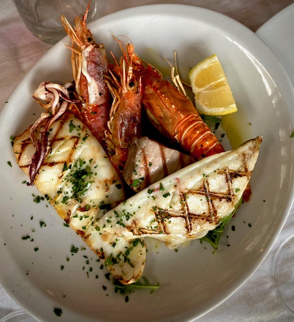 Meeresfrüchte vom Grill auf einem hellen Teller serviert.