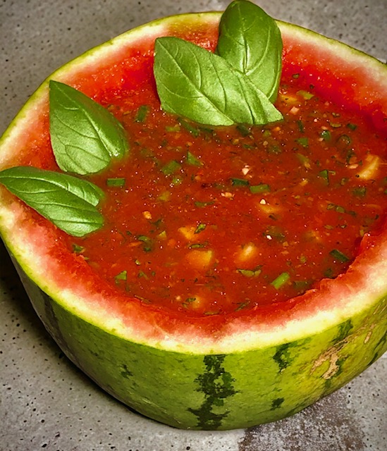 Eine asiatische Melonensuppe in einer halben Melone kalt serviert und mit ein paar Blättern Basilikum garniert. Erfrischend lecker! 