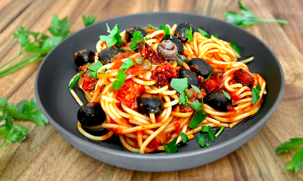 Spaghetti alla Puttanesca in einer grauen Schale serviert.