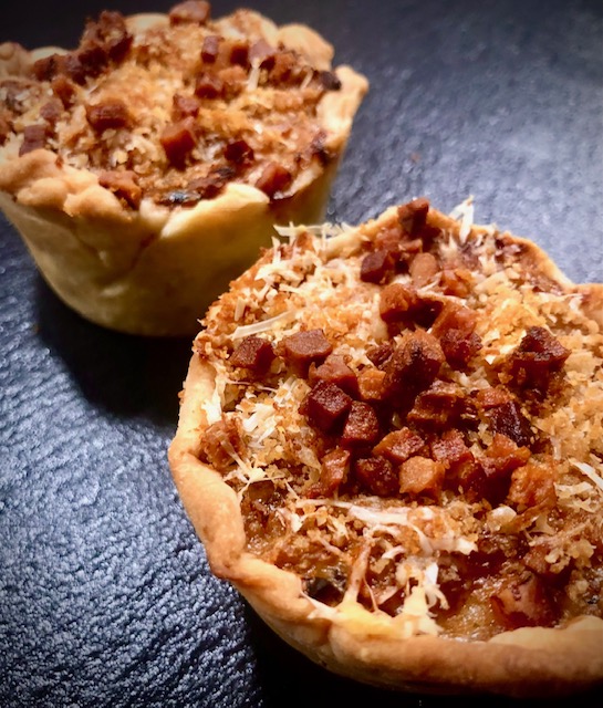 Weißkohl-Muffins auf einer grauen Schieferplatte serviert.