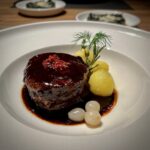 Rinderfielt mit Balsamico Sosse auf einem weißen Teller serviert.