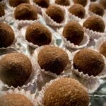 Fertige cremige Tiramisu-Trüffel mit dunkler Schokolade bestäubt.