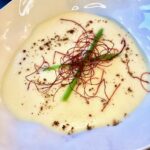 Feine Spargel-Kartoffelsuppe mit Kokosmilch verfeinert in einer dekorativen Schale serviert.