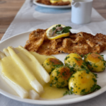Wiener Schnitzel mit Spargel, Sauce Hollandaise und Petersielen-Kartoffeln angerichtet.