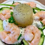 Erfrischendes Gurkengelee mit cremigem Joghurt und gekochtem Shrimps auf dekorativem Teller serviert.