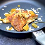 Joghurt-Kaiserschmarrn karamellisiert mit Mandelblätter und Limoncello, dazu einige Stücke frischer Pfirsich