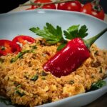 Türkische Schwiegermuttercreme mit einer Chillischote in einer Schale angerichtet.