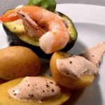 Teller mit Ofenkartoffeln, Shrimps und Avocado, ein leckeres Gericht, das sich für jede Gelegenheit eignet.