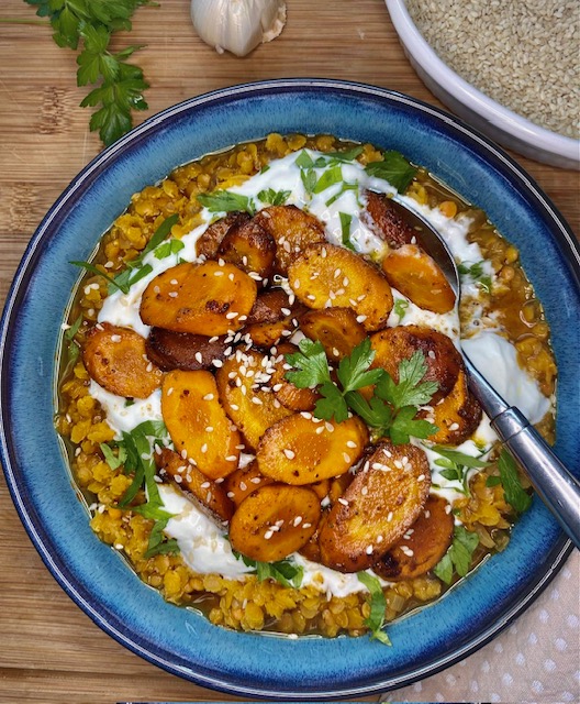 Linsen-Curry mit gerösteten Karotten in einer dekorativen Schale angerichtet