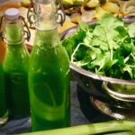 Ein grüner frischer Entgiftungssaft mit Spinat in Flaschen abgefüllt.