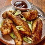 Chicken Wings aus dem Ofen mit einer leckeren BBQ-Soße und einigen Frühlingsrollen dekoriert.