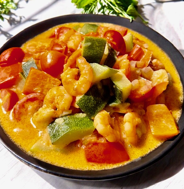 Wok-Gemüse mit Garnelen im einer Schale serviert.