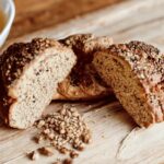 Roggen-Dingel-Brot, frisch gebacken und auf einer einer Holzunterlage angerichtet.