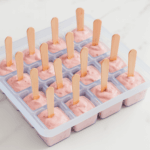 Rosa Himbeereis an einem Holzstiel in Silikon Eiswürfelform zum praktischen herausnehmen. Eisgekühlt lecker aus dem Gefrierfach.