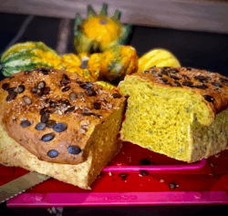 Kürbisbrot in der Coox-Wunderform gebacken und im Hintergrund mit Kürbissen dekoriert.
