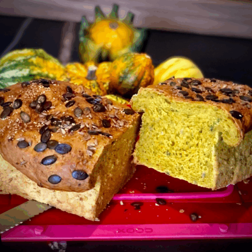 Kürbisbrot in der Coox-Wunderform gebacken und im Hintergrund mit Kürbissen dekoriert.