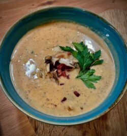 Cremige Maronensuppe mit Pilzen, knusprigem Speck und Petersilie in blauer Schale. Harecker Winter Rezept.