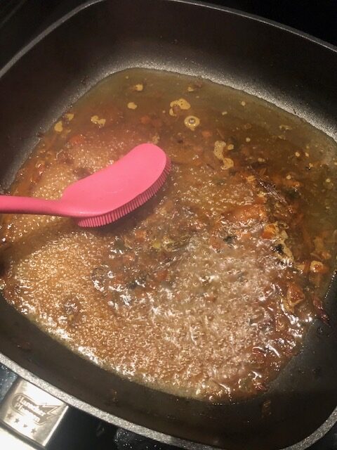 Schonende Reinigung einer beschichteten Pfanne mit einer Silikon-Spülbürste und Wasser ohne Spülmittel.