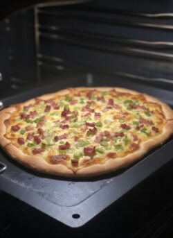 Ein leckerer original Elsässser Flammkuchen ohne Hefe der auf einem Gussbackblech von Pfannen Harecker im Ofen backt