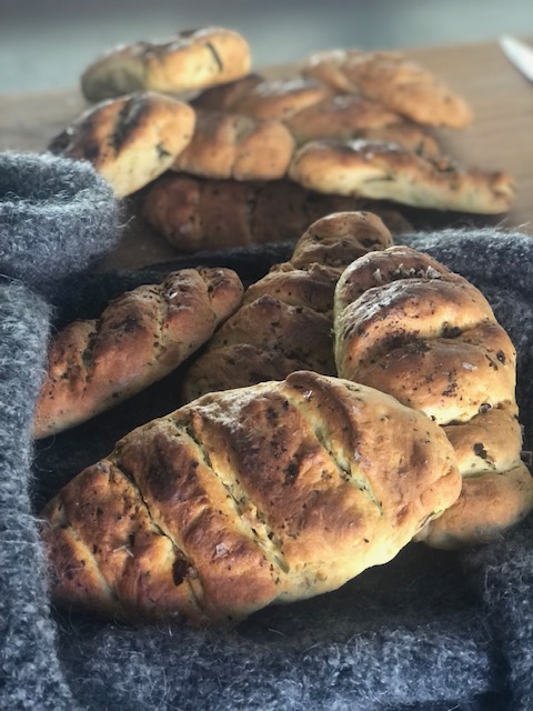 Fertige Bärlauch-Fougasse knusprig und rustikal präsentiert auf einer grauen Decke noch heiß aus dem Ofen zum auskühlen.