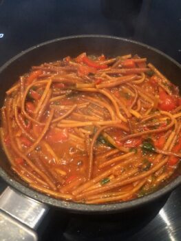 Die Spaghetti-all-assassina in einer dampfenden Pfanne beim einkochen. Die angebratenen Spaghetti werden immer wieder mit Wasser oder einer Brühe aufgegossen .... es duftet aus der Panne und zischt und blubbert beim kochen.